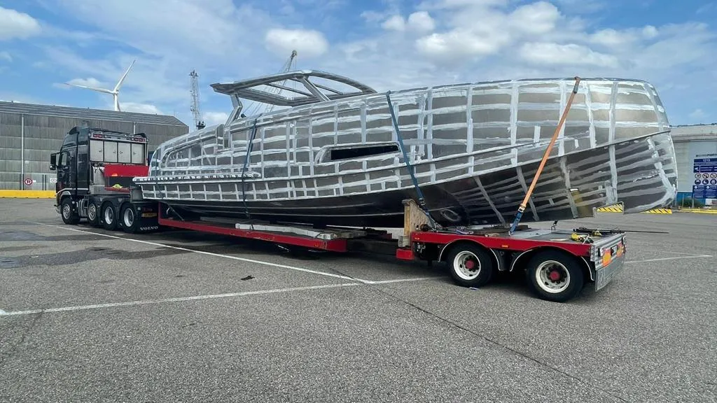 Aluminum boat on a Volvo truck low-loader.