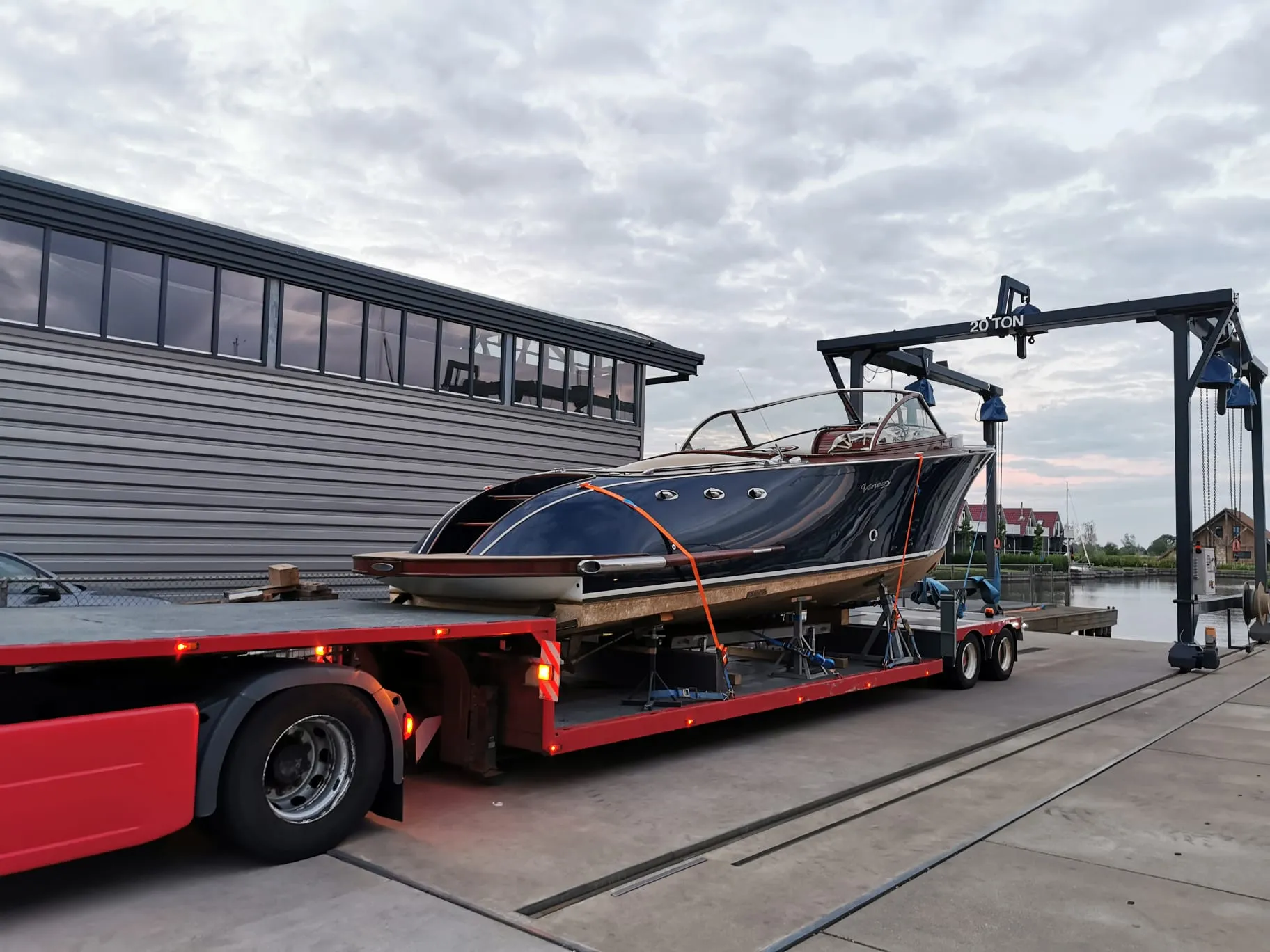 Classic motorboat on a low-loader trailer next to a 20-ton marina lift.