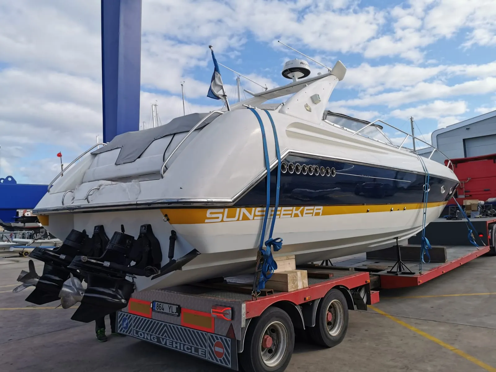 Sunseeker cruiser secured on a red low-loader trailer.